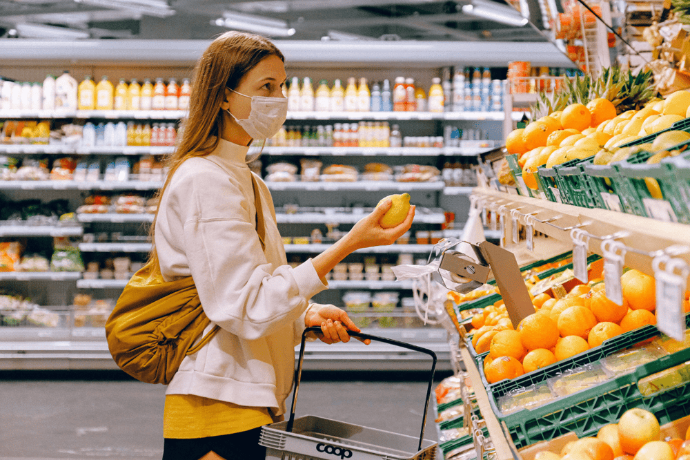 Woman grocery shopping wearing a face mask